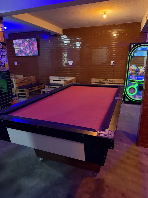Mesa de sinuca da Furts com tecido rosa e iluminação roxa